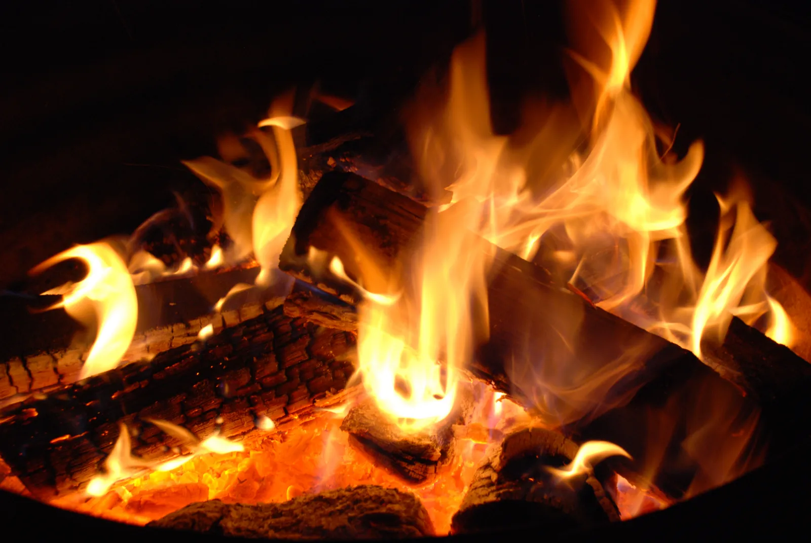 Brennende Holzscheite mit hellen Flammen und Glut